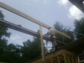 Carpenter setting a ridge beam over a new addition frame — Ice Dam Removal by Roofing Brothers in Forestburgh