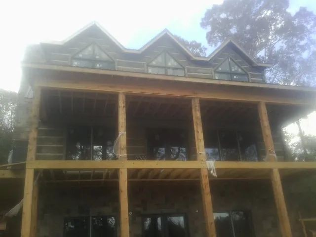 Dormers and porch framing on a large log home under construction — Roof Coating work by our crew in Forestburgh