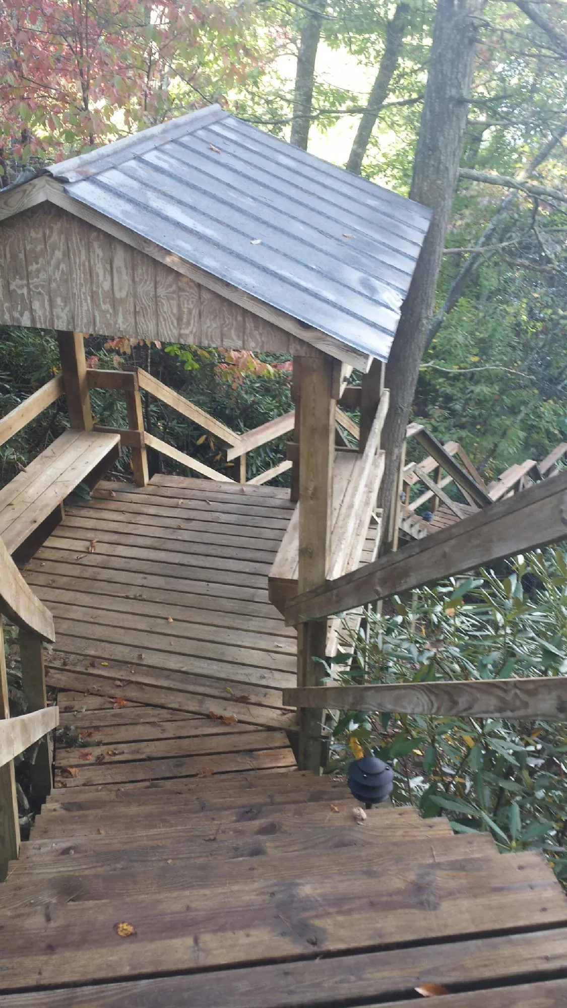 Metal roofed shelter over wooden steps on a wooded walkway — Skylight Repair & Installation work by our crew in Forestburgh